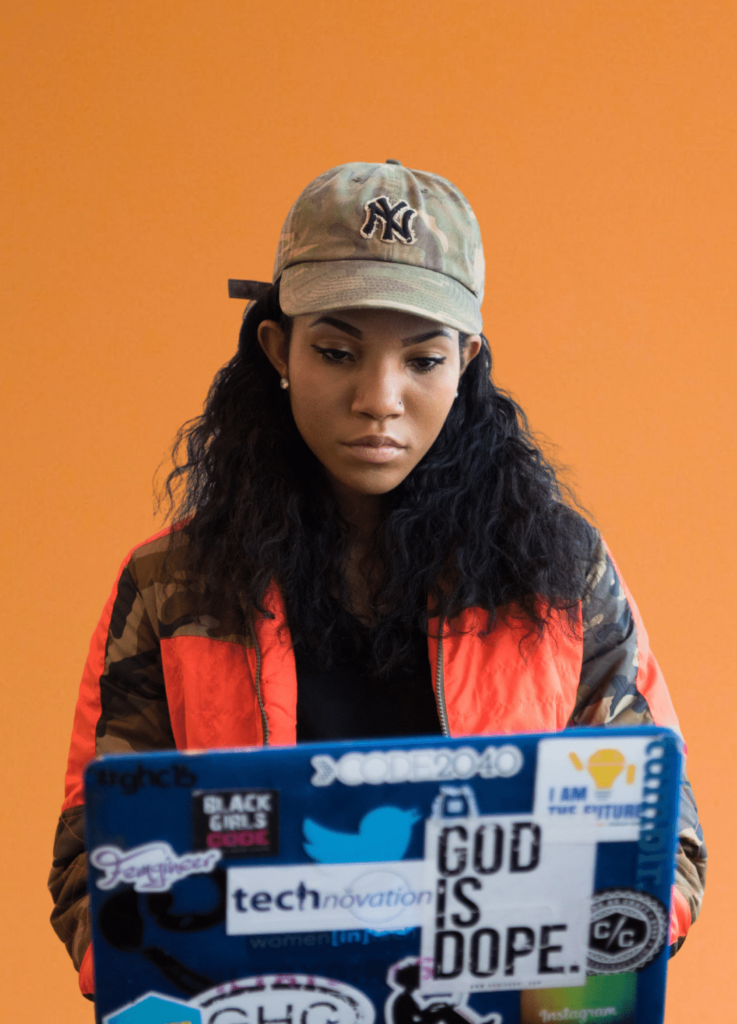 diversity in tech - stylish women working on laptop covered in technology stickers
